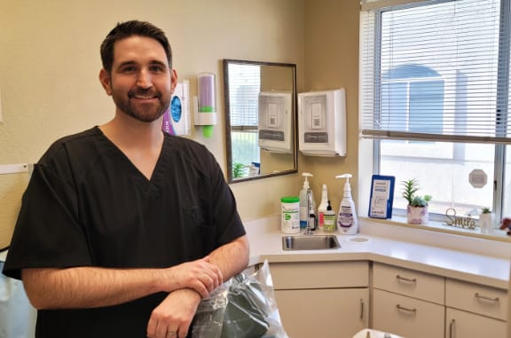 Dr Locascio portrait resting his arms on a dental chair