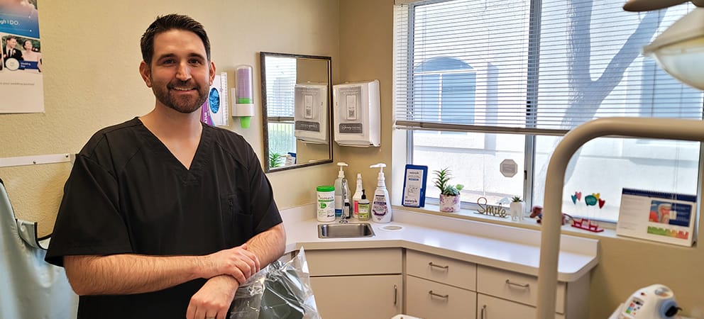 photo of Dr. Locascio smiling and posing with his arms on a dental chair